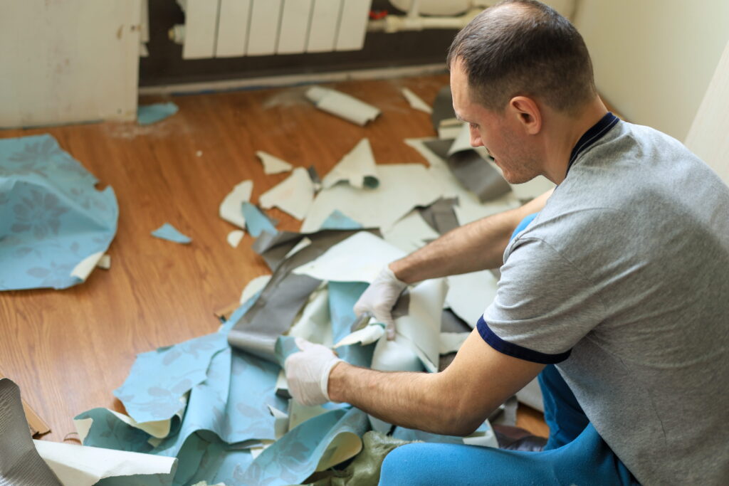 man-removing-old-wallpaper-from-room-interior-2026-03-17-07-10-29-utc (1)
