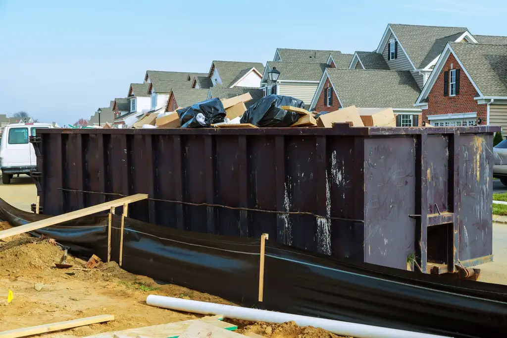 Full bin of garbage bags and debris on a new-home building site