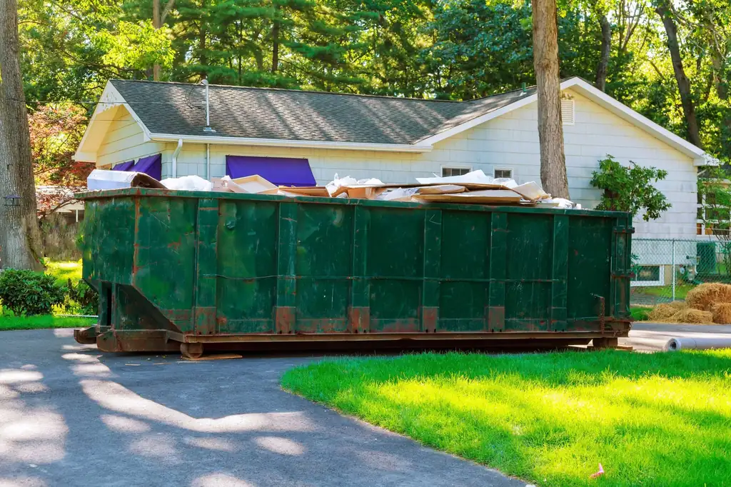 Full bin of clean-out waste on a residential driveway